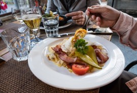 A fancy rösti or röschti dinner plate can be heaped with potatoes, egg, bacon, tomato and pickles in the Lauterbrunnen village