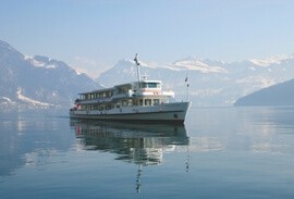 Boat on a lake in Switzerland with Alps mountains behind